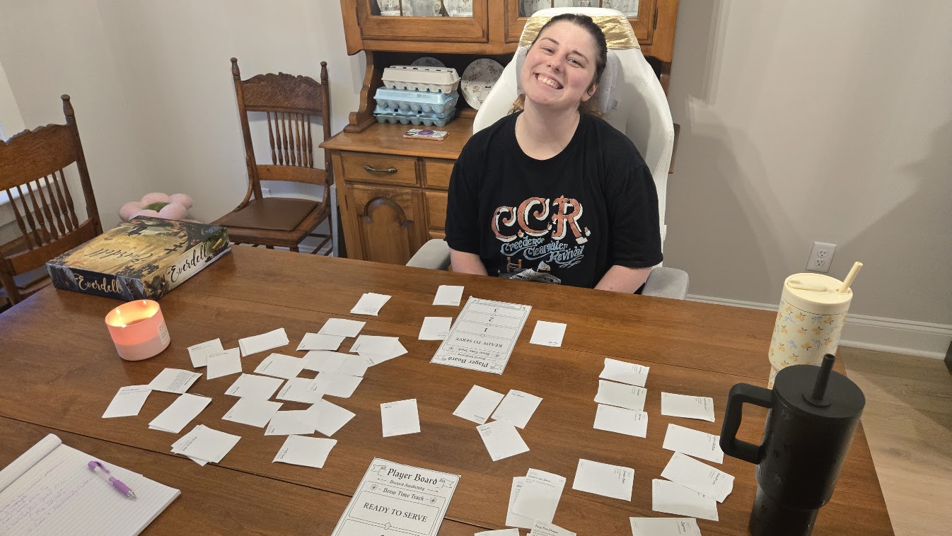 A first playtest at the kitchen table, candle lit, a spread of paper cards.